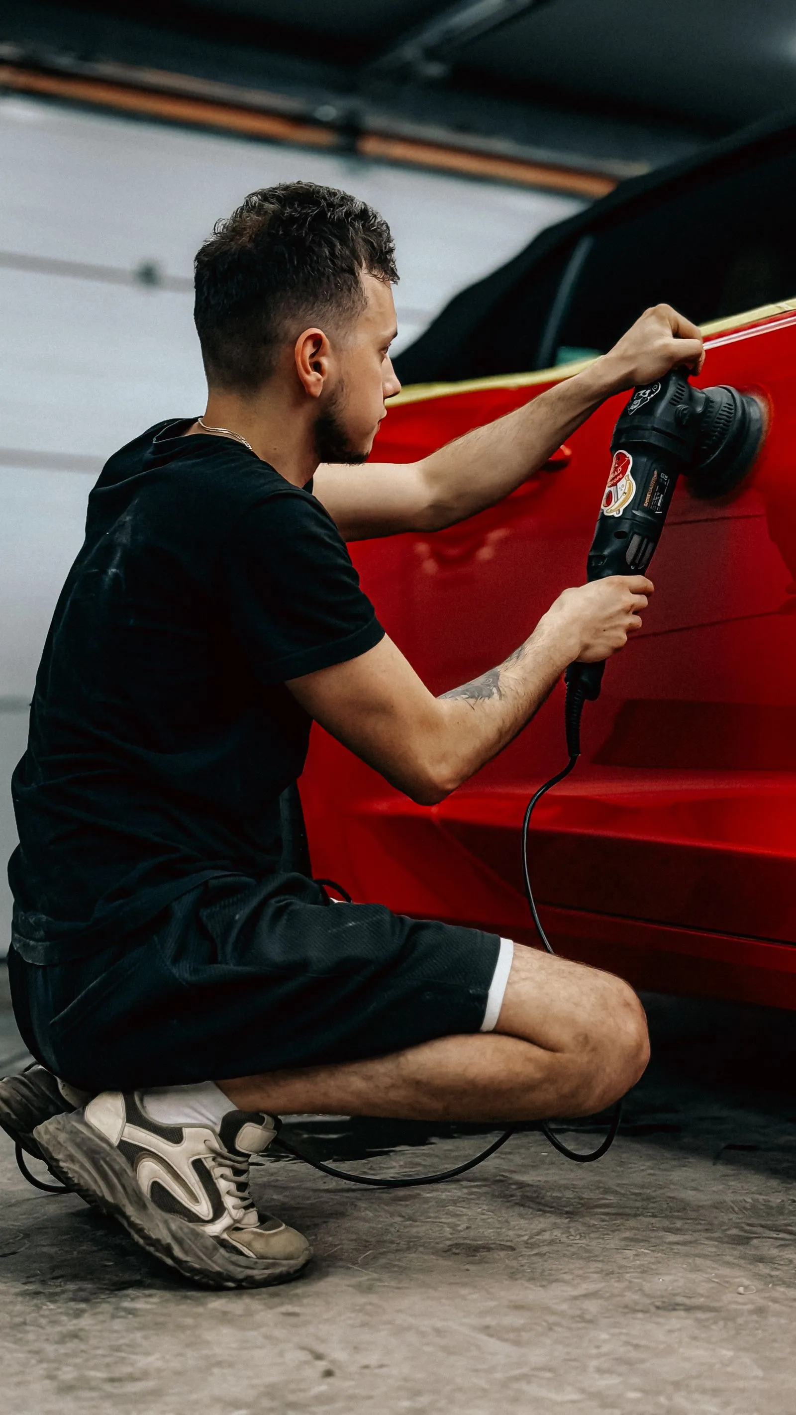 Final polish on a red coupe