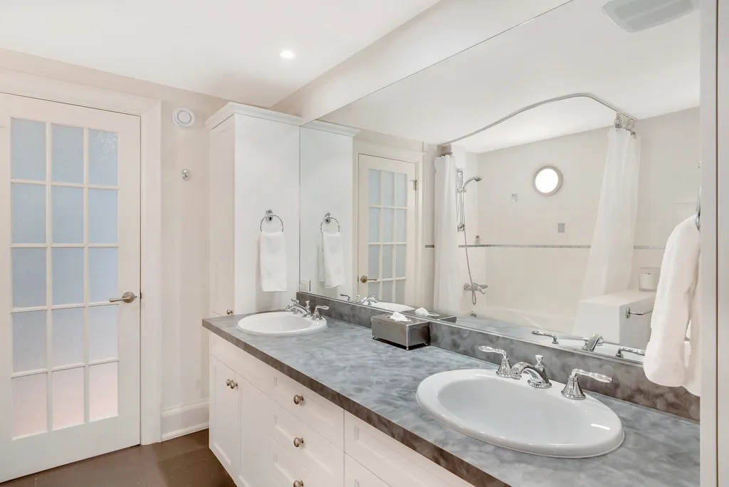 A renovated bathroom: double vanity with two basins and a wall-wide mirror