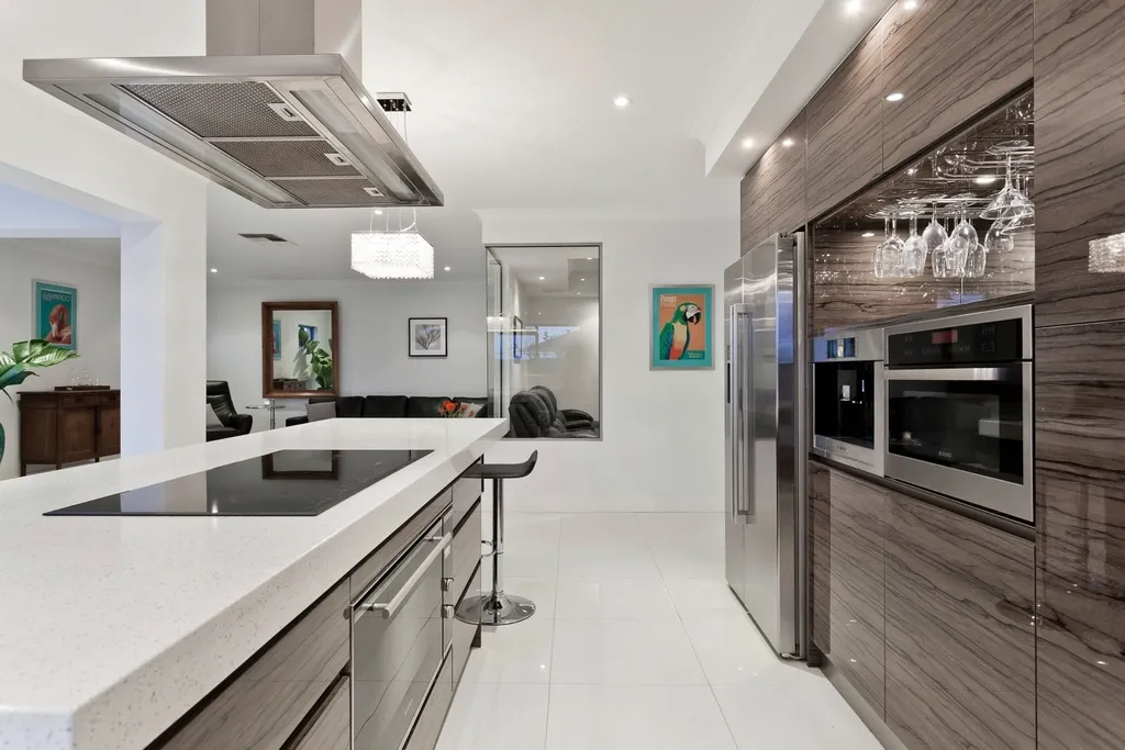 A custom kitchen: island with a cooktop and floor-to-ceiling veneered cabinets